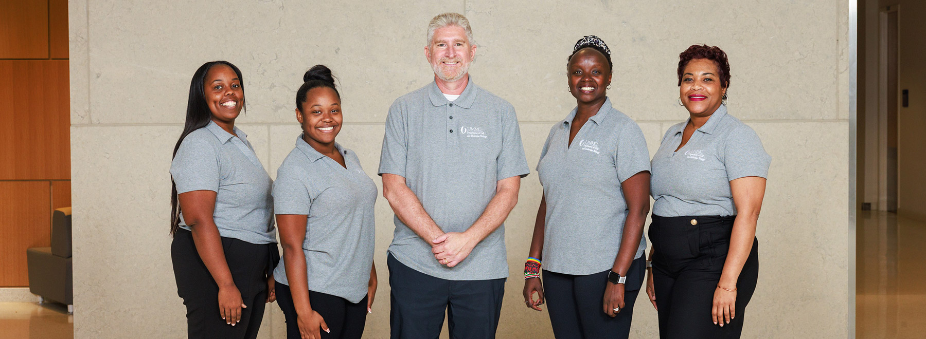 Group portrait of members of the Department of Cell and Molecular Biology inside the School of Medicine lobby. There is a stairase behind them.